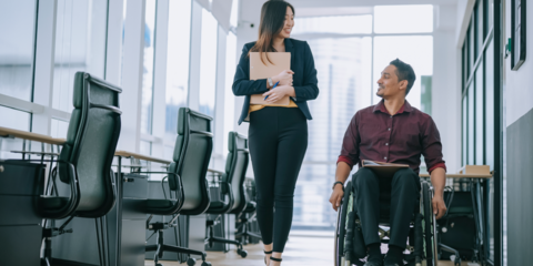Accessible photo of man in a wheelchair talking with a colleague 