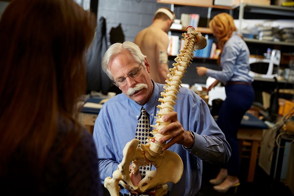 Stuart McGill with holding model of the spine.