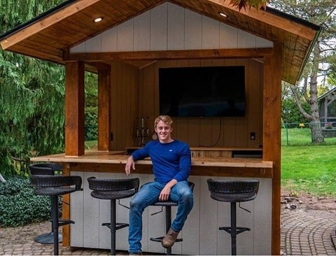 Student sitting in front of a backyard bar