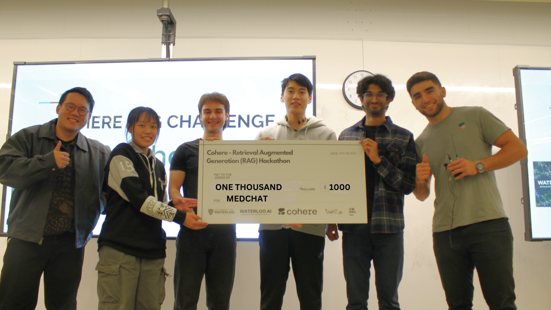 The Medchat team (L-R: Yilei Wang, Carter Demars, Ken Wu, and Areel Khan) holding a $1000 cheque, flanked by Ivan Zhang and Faraz Khoubsirat
