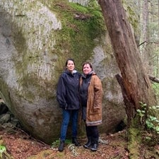 Jessica Silver and Susan Roy in front of large mossy stone