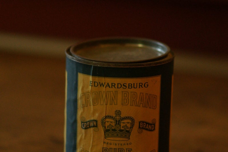 A can with clear signs of age, labled "edwardsburg Crown Brand Corn Syrup" on a yellow and blue label