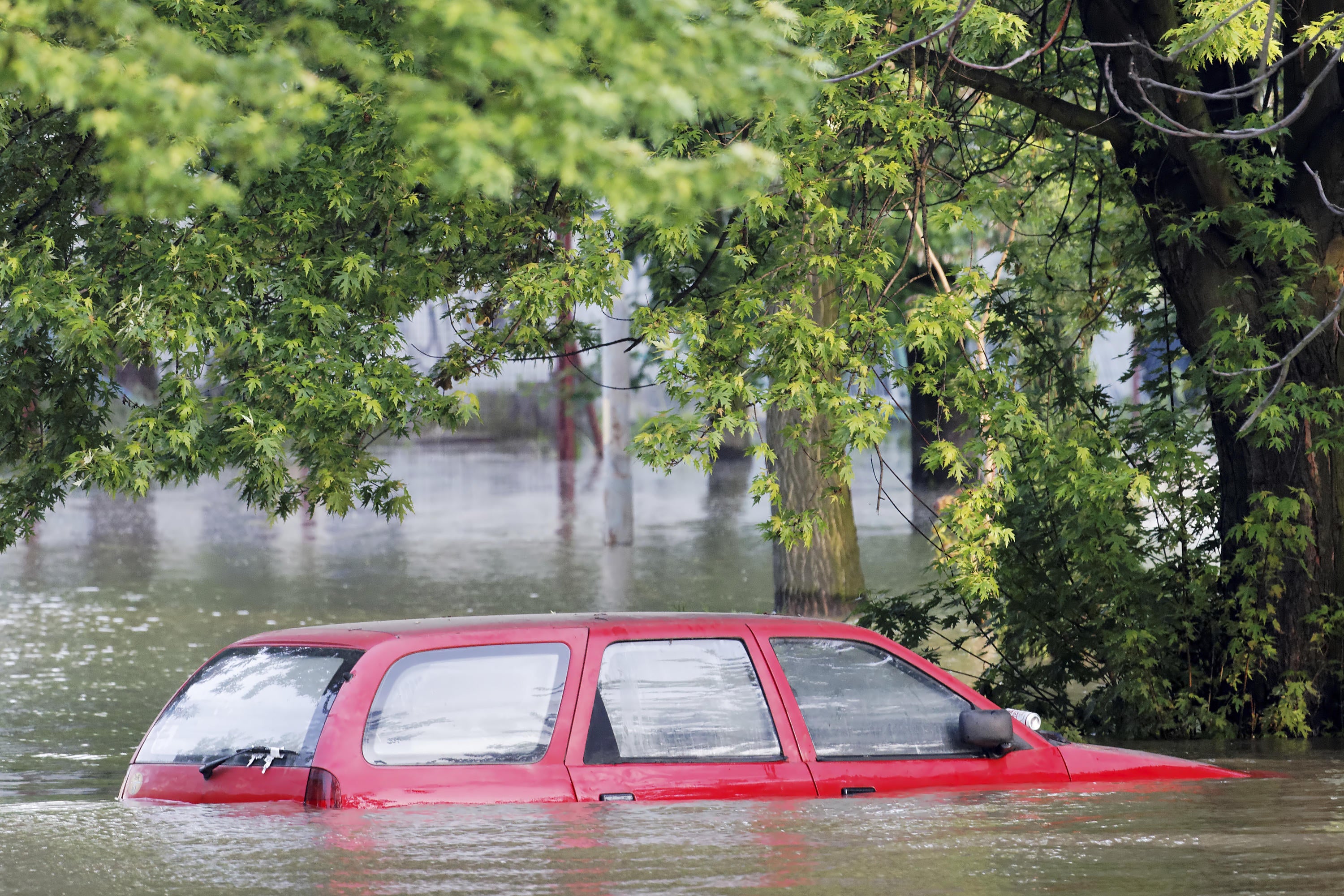 a SUV is submerged in flood waters on a city street