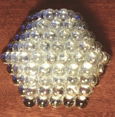 four layers of clear glass sphere stacked together to form a model of a nanoparticle