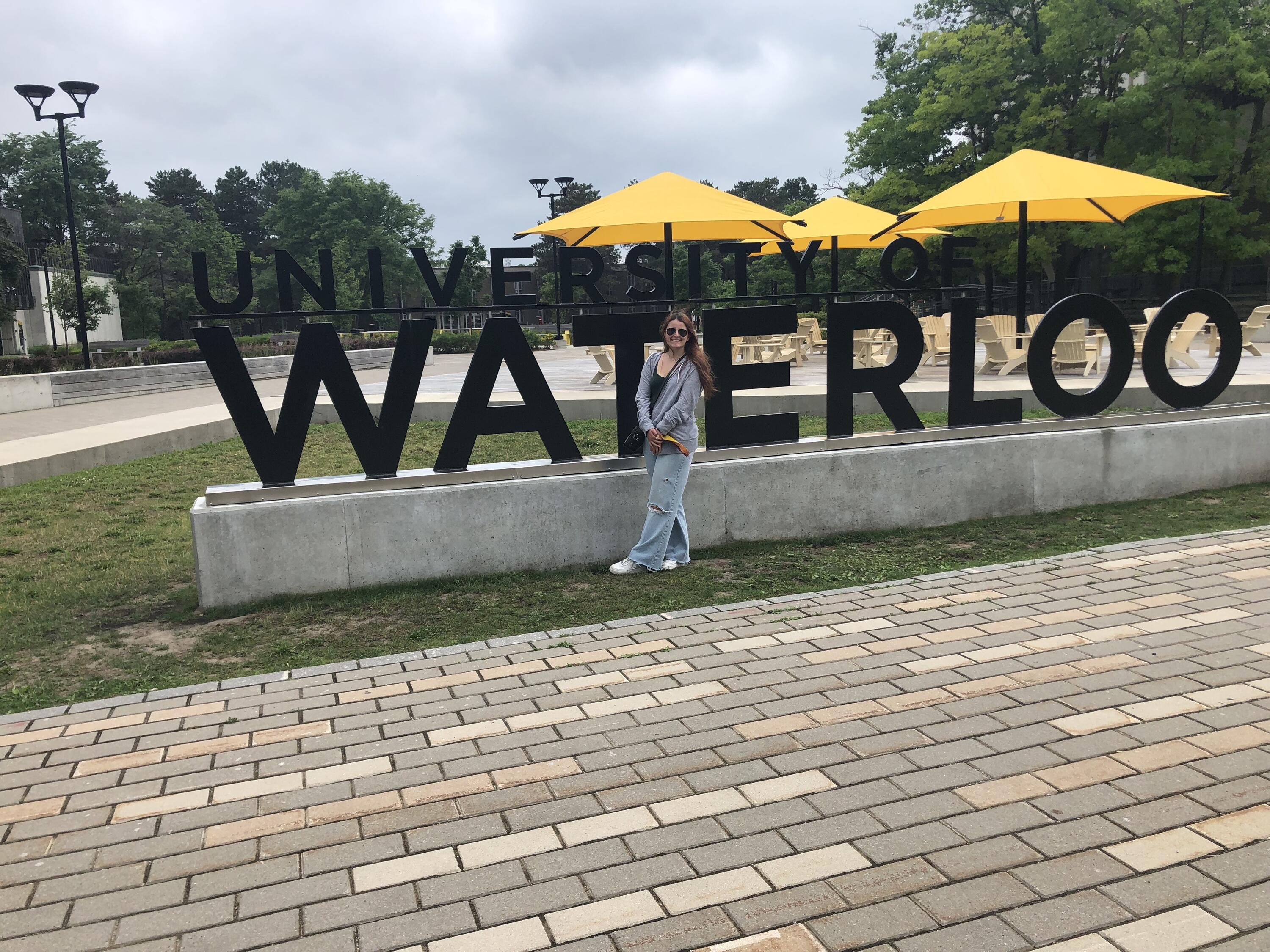 Maddie in front of the University of Waterloo sign