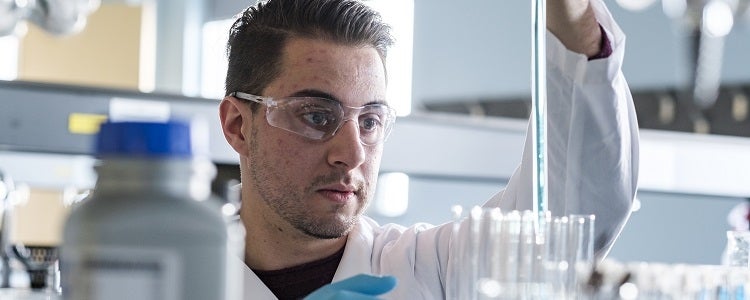 A student in one of Waterloo's Physical Sciences programs works with a pipette in a lab