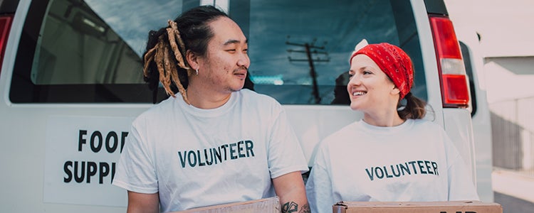 Two volunteers smiling with each other.
