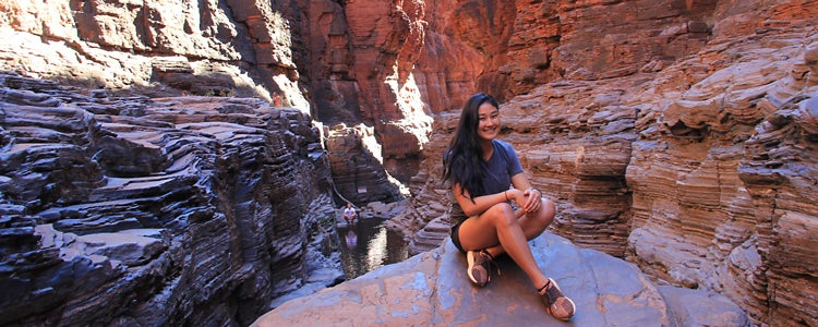 Study abroad student sitting on rock in canyon