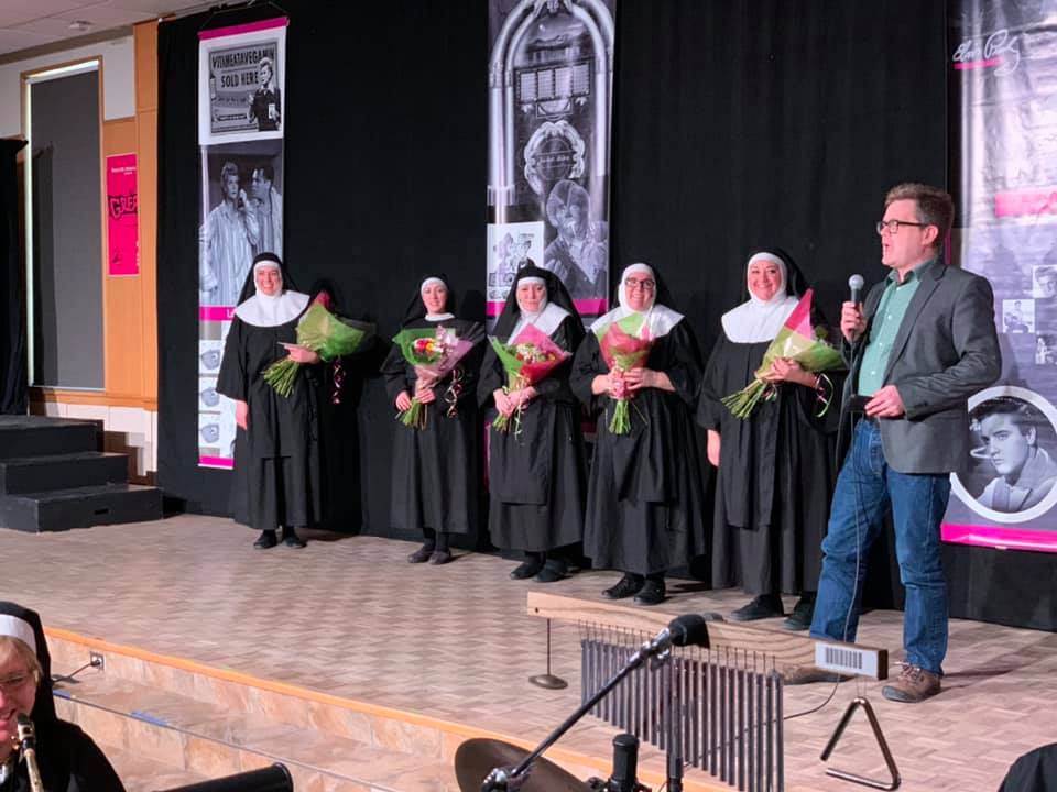 The cast of Nunsense holds flowers and are thanked by president Marcus Shantz