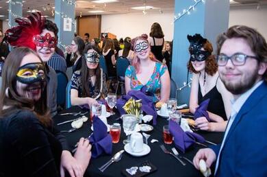students sitting at dining room table dressed in masquerade costume