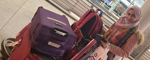Reema standing beside luggage bags in airport