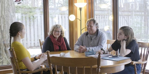 Paul and Dolores sit with two Grebel students in their home.