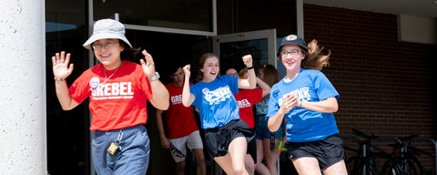 Students entuhisastically run out of the front doors of Grebel to welcome the crowd on move in day.