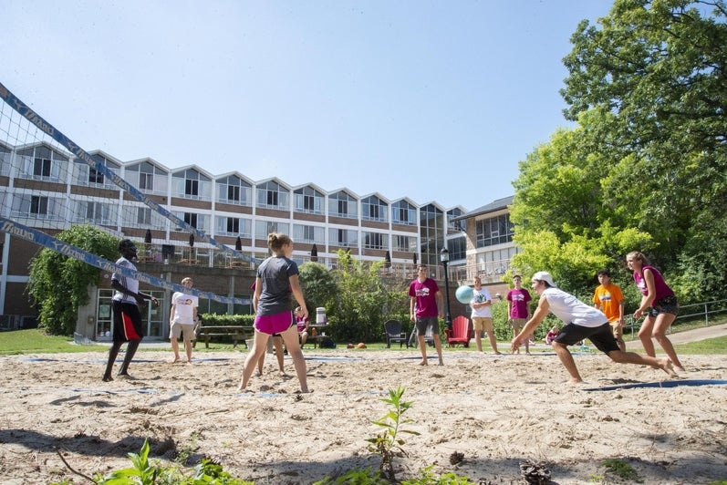 Students playing beach volleyball in Grebel court