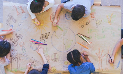 Children drawing a mural of a healthy world.