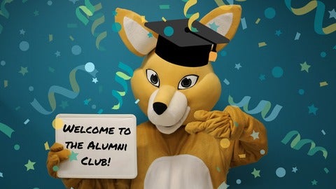 Mascot AHSSIE in graduation cap holding Welcome to the Alumni Club sign.