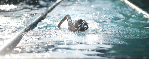 Competitive swimmer racing in swimming lane.