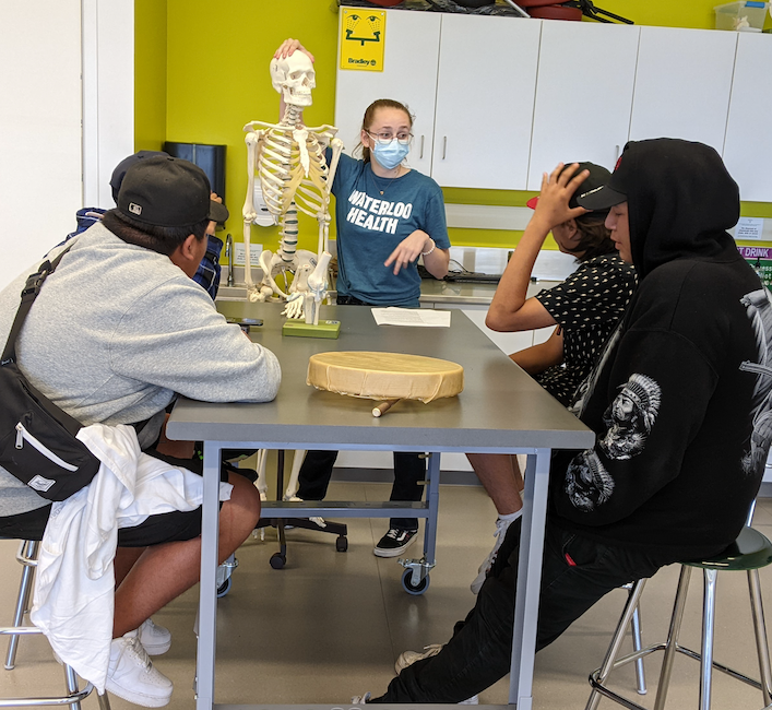 Students around a table with a skeleton in the Anatomy Lab