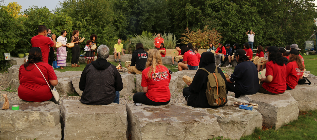 Students sitting around a ceremonial fire pit