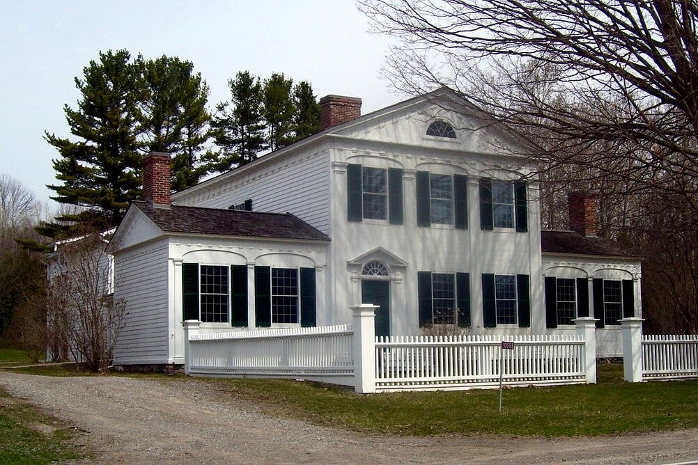 A white house with a white picket fence out front named Barnum House in Grafton, Ontario