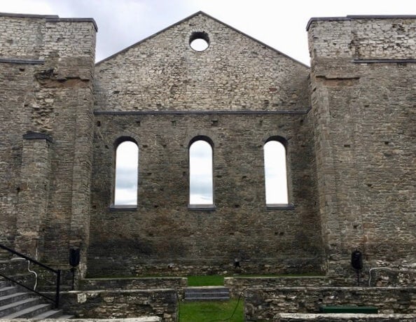 Church transept, stone wall with windows, no roof and stairs