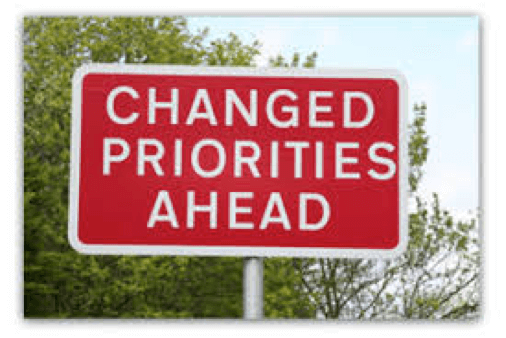 A sign reading "Changed Priorities Ahead"