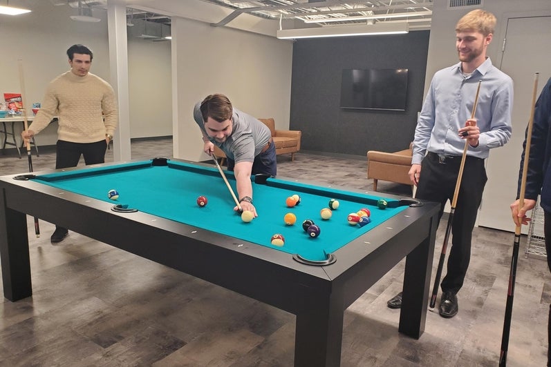 MAC LLP co-op students playing pool at the office