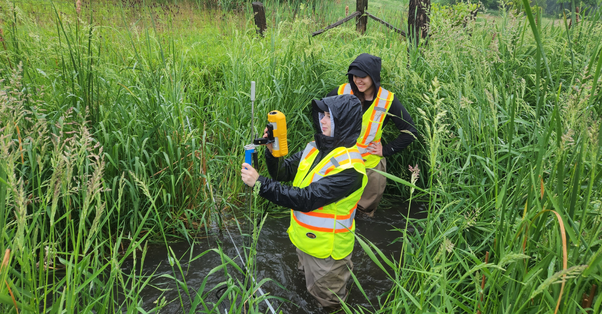 Two students taking samples on land during a co-op work term with GHD