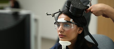 Researcher subject's face with chin on pedestal receiving transcranial magnetic stimulation.