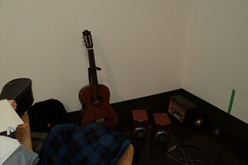 Guitar and speakers in corner of gallery.