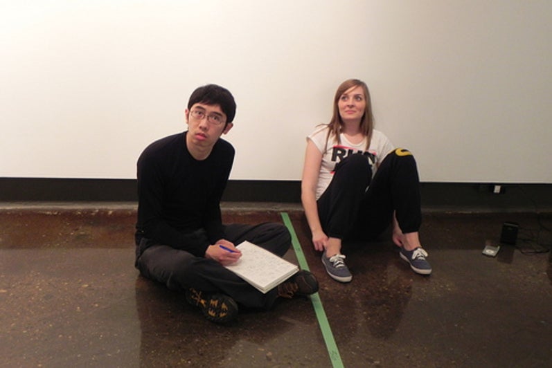 Keith and Liz sitting together on the floor of the gallery.