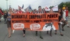 Allie Bly at a protest holding a large orange sign 