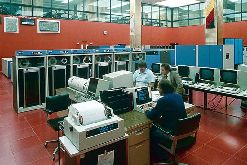 Men work at computers in the red-coloured Computer Centre