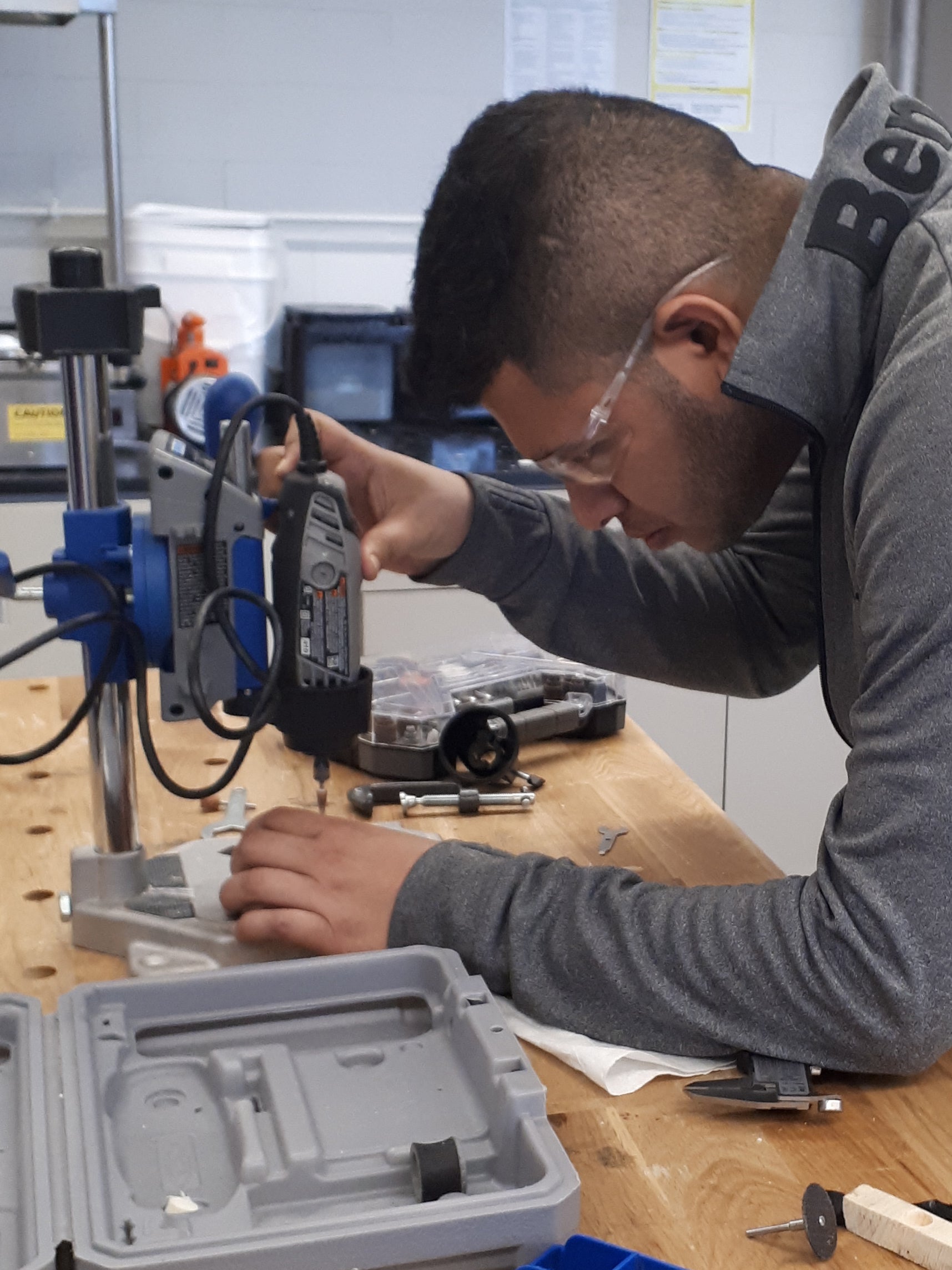 Student focused on working with a Dremel 3000 rotary tool