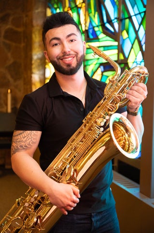 Matthew Metwalli holding his baritone saxophone