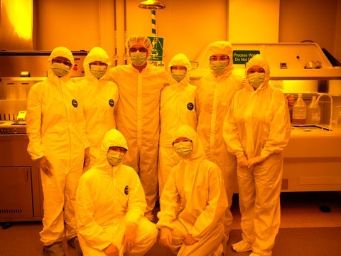 a group of lab techs in clean room suits in the clean room
