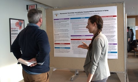 Pharm 401 student talking to a faculty member about their research poster