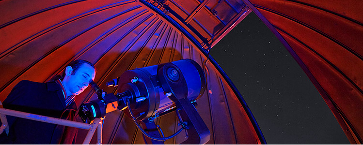 Observatory guide Robbie Henderson views the stars through the telescope.