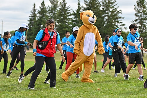 Orientation leaders do Faculty dance with mascot on orientation week.