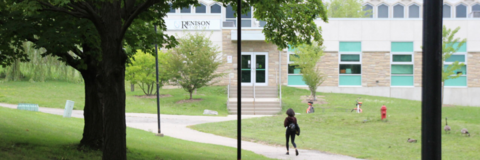 Student walking up a path toward the Renison entrance. 