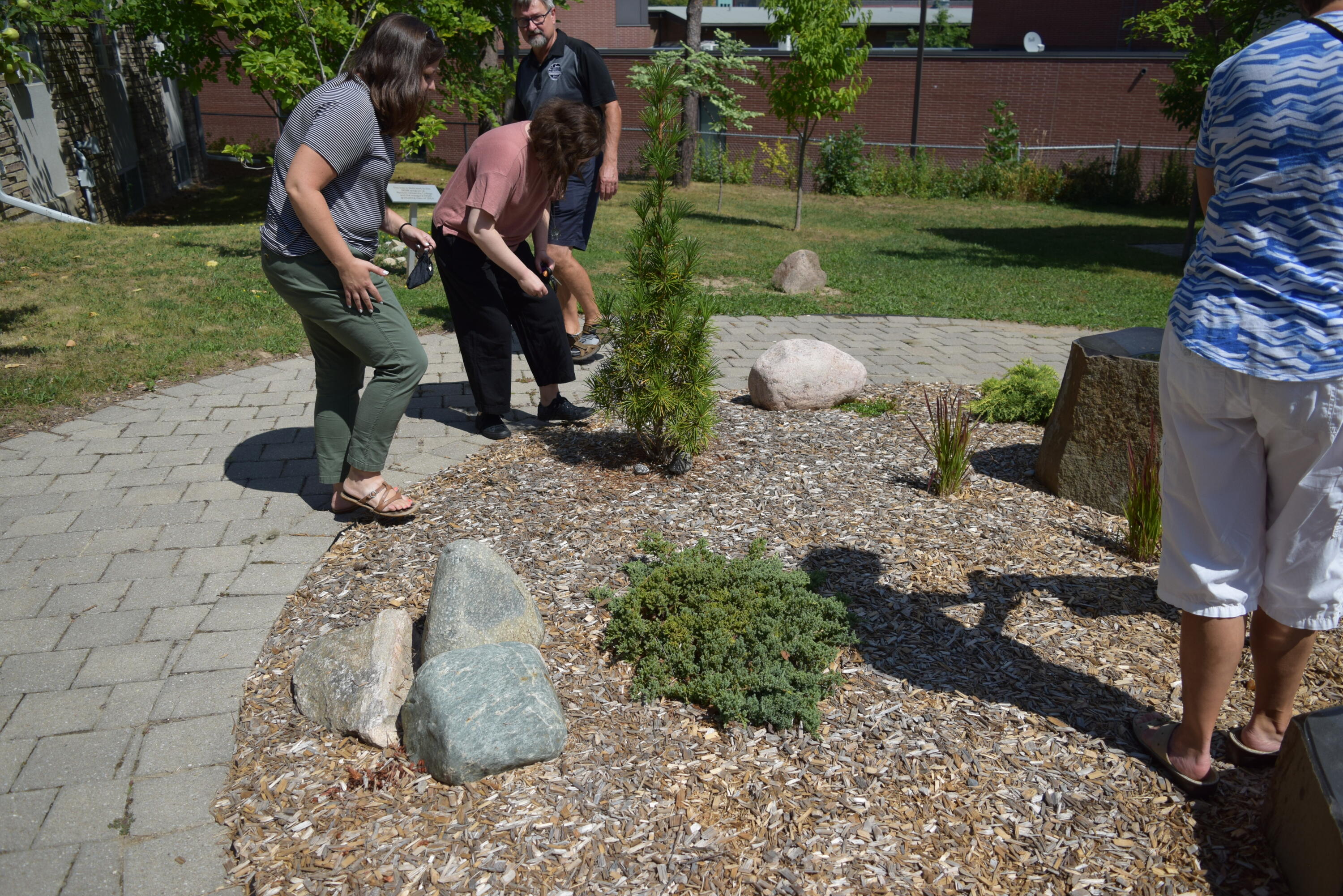 Renison community members are shown in the garden placing their stones.
