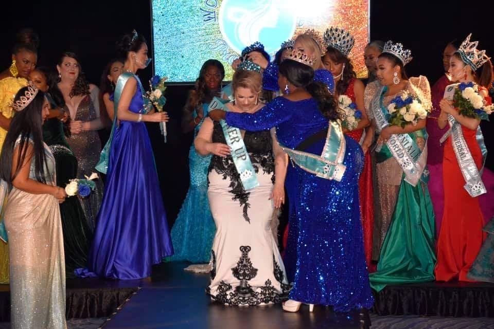 Malissa, shown centre wearing a black and white gown, as she is crowned. 