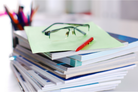 Reports, pen and eye glasses on a desk