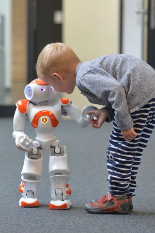 A child shaking hand with a robot