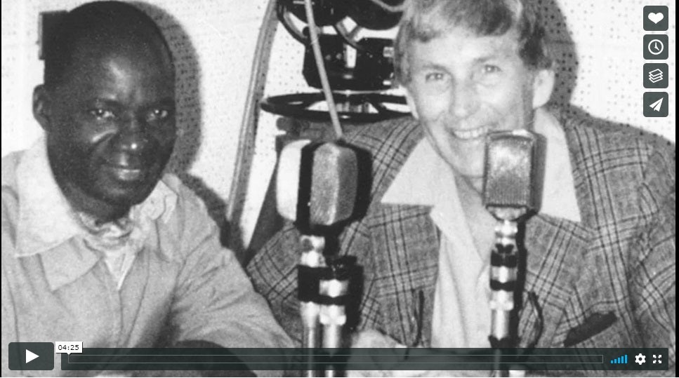 in a still taken from a video, two men behind old style microphones