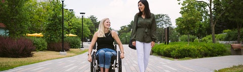 person in a wheelchair with an able-bodied person