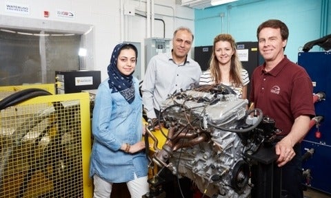 Parisa Golchoubian, Nasser Azad, Stefanie Bruinsma and John McPhee standing around an engine.
