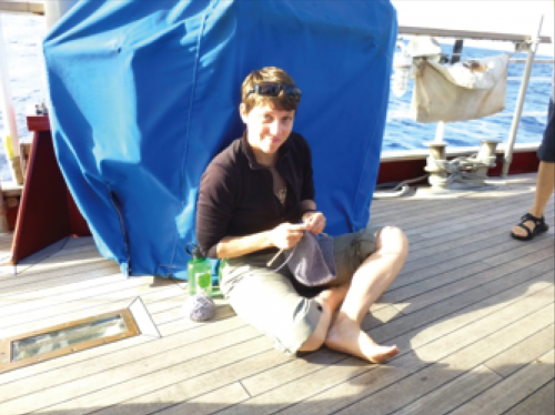Person knitting on the quarter-deck.