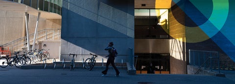 A person walking in front of the Math and Computer building with a blue overlay