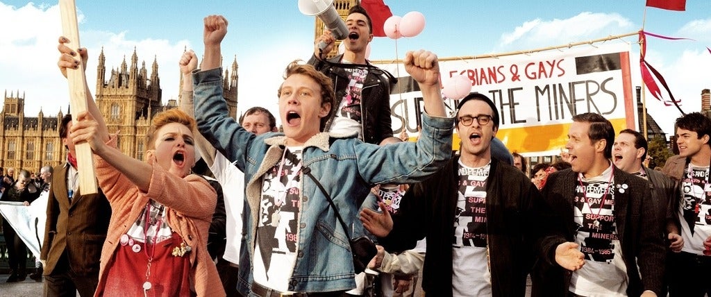 An image from the movie Pride depicting a group of people protesting